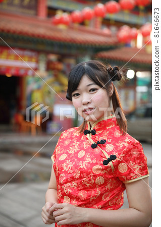 beauty woman wear red cheongsam looking and smile in chinese new year 81646673