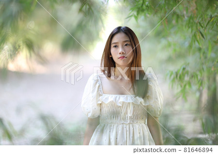 Beautiful young woman with white dress on garden background Beautiful young woman with white dress on garden background 81646894