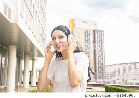 teen girl listening to music with headphones outdoors teen girl listening to music with headphones outdoors 81646963