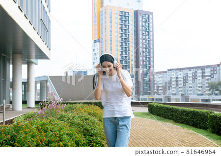 teen girl enjoying music with headphones outdoors 81646964