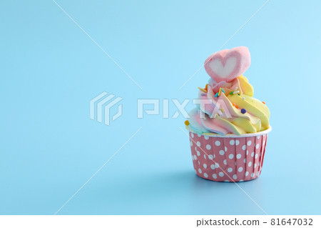 Colorful cupcake isolated in blue background Colorful cupcake isolated in blue background 81647032