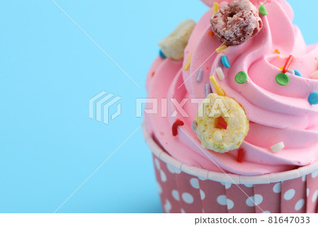 pink cupcake isolated in blue background pink cupcake isolated in blue background 81647033