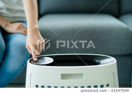 Woman using and changing air purifier filter. Woman using and changing air purifier filter. 81647099