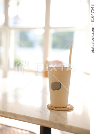 Iced coffee with paper glass in coffee shop background Iced coffee with paper glass in coffee shop background 81647548