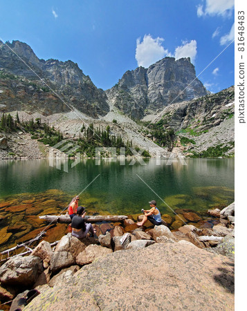 Three young hikers relax by Emerald Lake in Rocky Mountain Nat'l Park, Colorado. 81648483