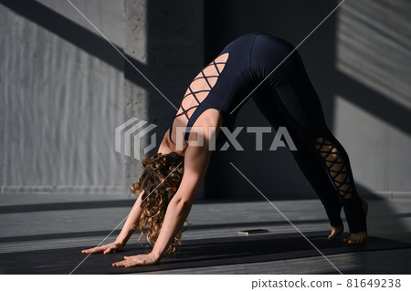 Young woman practicing yoga poses in an urban background on sunny day 81649238