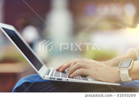 在戶外使用筆記本電腦的人手邊特寫綠色背景模糊 在戶外使用筆記本電腦的人手邊特寫綠色背景模糊 81650269