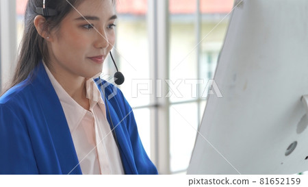 Businesswoman wearing headset working actively in office Businesswoman wearing headset working actively in office 81652159