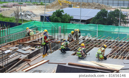 SEREMBAN, MALAYSIA -JULY 01, 2016: Construction workers working at the construction site at Seremban, Malaysia during daytime. They are wearing proper safety gear to ensure they are safe working. SEREMBAN, MALAYSIA -JULY 01, 2016: Construction workers working at the construction site at Seremban, Malaysia during daytime. They are wearing proper safety gear to ensure they are safe working. 81656146