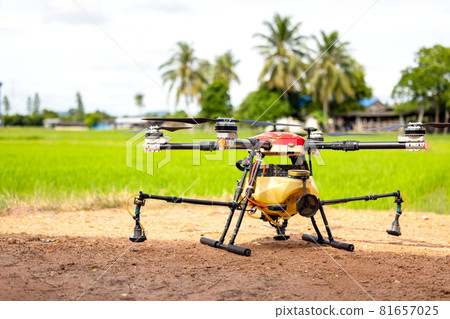 Agriculture drones fly over rice fields sprinkling fertilizer, High-resolution photographs of industrial drones spraying chemicals on rice paddies and fields Agriculture drones fly over rice fields sprinkling fertilizer, High-resolution photographs of industrial drones spraying chemicals on rice paddies and fields 81657025