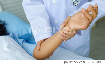 Doctor hold hand of patient on bed in hospital and checkup nervous system for cure and treatment. Concept of Guillain barre syndrome and numb hands disease or vaccine side effect Doctor hold hand of patient on bed in hospital and checkup nervous system for cure and treatment. Concept of Guillain barre syndrome and numb hands disease or vaccine side effect 81659896