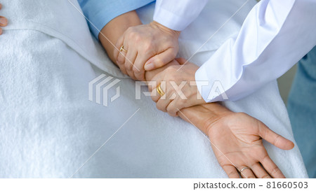 Doctor hold hand of patient on bed in hospital and checkup nervous system for cure and treatment. Concept of Guillain barre syndrome and numb hands disease or vaccine side effect Doctor hold hand of patient on bed in hospital and checkup nervous system for cure and treatment. Concept of Guillain barre syndrome and numb hands disease or vaccine side effect 81660503