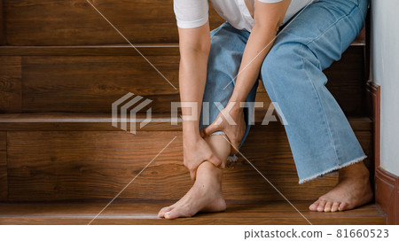 Woman sitting when cannot walk on stairs and stops then hold her legs for support and rest with feel tingling. Concept of Guillain barre syndrome and numb legs disease or vaccine side effect. 81660523