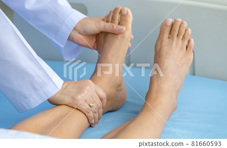 Doctor holds legs patient on bed in hospital and checkup nervous system for cure and treatment. Concept of Guillain barre syndrome and numb hands disease or vaccine side effect 81660593