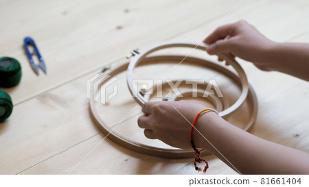 Embroider sewing by woman hand. Craft work and female hands. Handicraft work by thread needle sew knit. Wood frame embroidery hoop. Needlework handicraft crafting quarantine leisure concept. Embroider sewing by woman hand. Craft work and female hands. Handicraft work by thread needle sew knit. Wood frame embroidery hoop. Needlework handicraft crafting quarantine leisure concept. 81661404