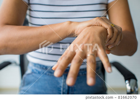 Woman in using hand to hold wrist and stretching fingers. with feeling pain, suffer, hurt and tingling. Concept of Guillain barre syndrome and numb hands disease Woman in using hand to hold wrist and stretching fingers. with feeling pain, suffer, hurt and tingling. Concept of Guillain barre syndrome and numb hands disease 81662070