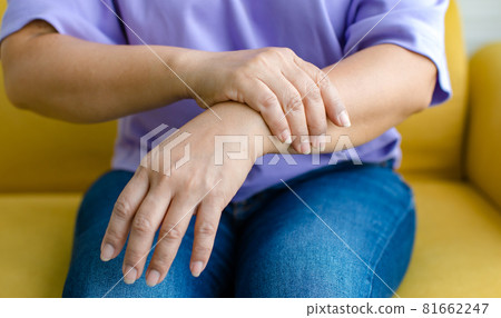 Woman using hand to hold other her arm with feeling pain, hurt and tingling. Concept of Guillain barre syndrome and numb hands disease Woman using hand to hold other her arm with feeling pain, hurt and tingling. Concept of Guillain barre syndrome and numb hands disease 81662247