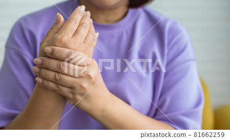 Woman using hand to hold other of her hand with feeling pain, hurt and tingling. Concept of Guillain barre syndrome and numb hands disease Woman using hand to hold other of her hand with feeling pain, hurt and tingling. Concept of Guillain barre syndrome and numb hands disease 81662259