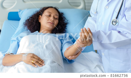 Doctor holds the hand of Asian female patient on bed in hospital and checkup nervous system for cure and treatment. Concept of Guillain barre syndrome and numb hands disease or vaccine side effect 81662736