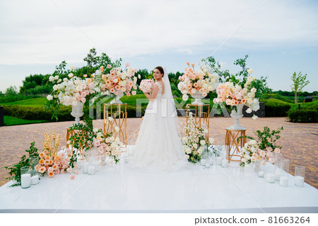 bride in the wedding ceremony area of live white and pink flowers. bride in the wedding ceremony area of live white and pink flowers. 81663264