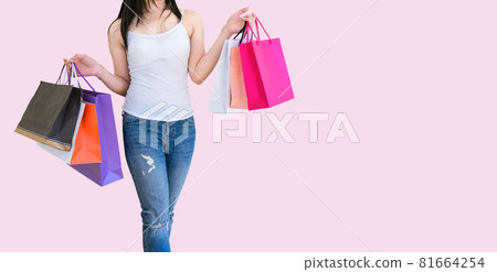 woman holding a shopping paper bag pink background 81664254