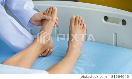 Doctor holds legs patient on bed in hospital and checkup nervous system for cure and treatment. Concept of Guillain barre syndrome and numb hands disease or vaccine side effect Doctor holds legs patient on bed in hospital and checkup nervous system for cure and treatment. Concept of Guillain barre syndrome and numb hands disease or vaccine side effect 81664646