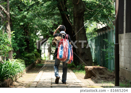 一個背著家庭用品的男人，背影 81665204