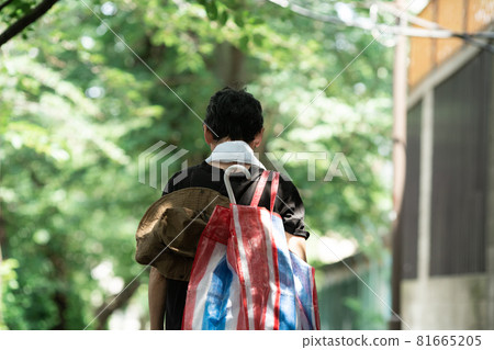 一個背著家庭用品的男人，背影 81665205