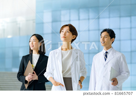 Image of female doctors and male and female medical staff lined up at the entrance of the hospital 81665707