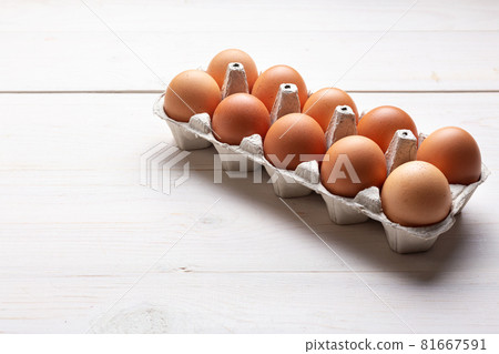 Fresh organic chicken eggs in carton pack or egg container on white wood background. Fresh organic chicken eggs in carton pack or egg container on white wood background. 81667591