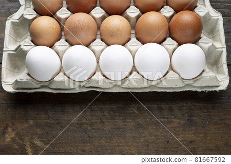 Chicken eggs in a tray on a wooden table. Chicken eggs in a tray on a wooden table. 81667592