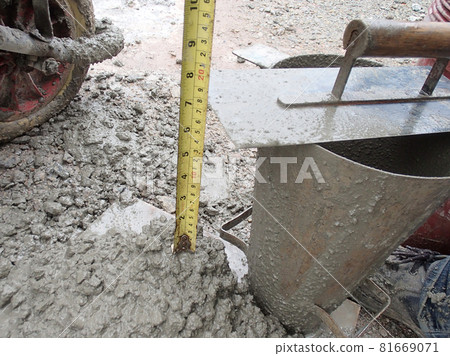 KUALA LUMPUR, MALAYSIA -DECEMBER 23, 2015: Construction workers doing slump test using specific equipment at the construction site. Witness by consultant.  KUALA LUMPUR, MALAYSIA -DECEMBER 23, 2015: Construction workers doing slump test using specific equipment at the construction site. Witness by consultant.  81669071