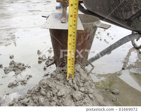 KUALA LUMPUR, MALAYSIA -DECEMBER 23, 2015: Construction workers doing slump test using specific equipment at the construction site. Witness by consultant.  81669072