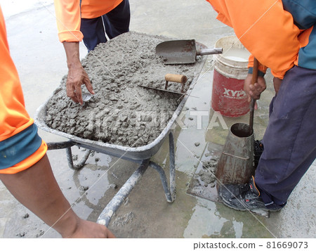 KUALA LUMPUR, MALAYSIA -DECEMBER 23, 2015: Construction workers doing slump test using specific equipment at the construction site. Witness by consultant.  81669073