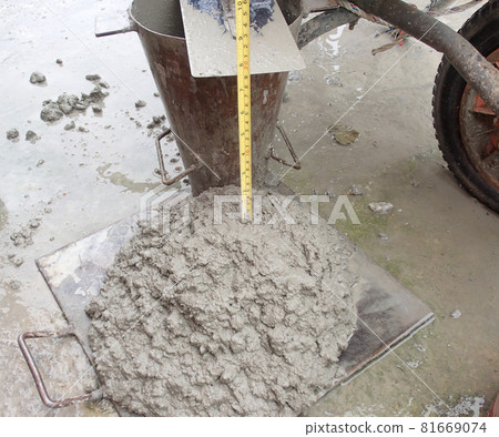 KUALA LUMPUR, MALAYSIA -DECEMBER 23, 2015: Construction workers doing slump test using specific equipment at the construction site. Witness by consultant.  81669074