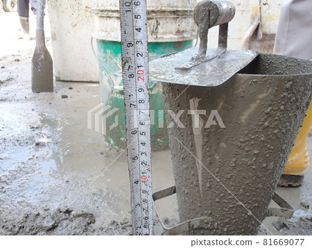 KUALA LUMPUR, MALAYSIA -DECEMBER 23, 2015: Construction workers doing slump test using specific equipment at the construction site. Witness by consultant.  81669077