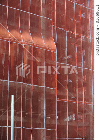 KEDAH, MALAYSIA -AUGUST 05, 2016: Layer of net used to cover the external wall scaffolding. It function is to prevent unwanted object falling outside from the construction site. KEDAH, MALAYSIA -AUGUST 05, 2016: Layer of net used to cover the external wall scaffolding. It function is to prevent unwanted object falling outside from the construction site. 81669611