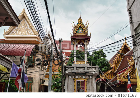 Guardian Nagas, Flags and Colorful decorated buildings mark the street entrance to Wat Nak Prok, The Naga Temple. 81671168