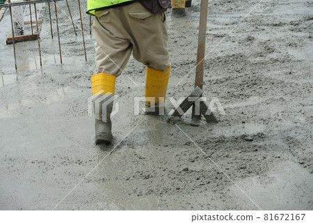 JASIN, MALAYSIA -NOVEMBER 13, 2015: Construction worker leveling wet concrete has been poured. They also use a vibrator machine in this work. JASIN, MALAYSIA -NOVEMBER 13, 2015: Construction worker leveling wet concrete has been poured. They also use a vibrator machine in this work. 81672167