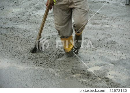 JASIN, MALAYSIA -NOVEMBER 13, 2015: Construction worker leveling wet concrete has been poured. They also use a vibrator machine in this work. JASIN, MALAYSIA -NOVEMBER 13, 2015: Construction worker leveling wet concrete has been poured. They also use a vibrator machine in this work. 81672180