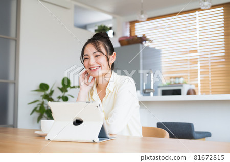 A woman watching a tablet terminal A woman watching a tablet terminal 81672815