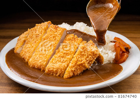 Pouring curry sauce on katsu curry 81674740
