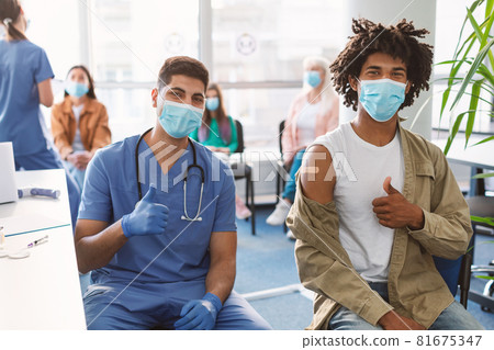 Vaccinated Black Guy And Doctor Gesturing Thumbs-Up At Hospital Vaccinated Black Guy And Doctor Gesturing Thumbs-Up At Hospital 81675347