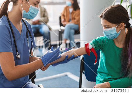 Teenage girl wearing face mask and medical tourniquet for jab 81675454