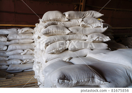 Large cloth bags with unknown bulk contents are lying in the warehouse. An image illustrating the products confiscated due to sanctions, or the capture of smugglers with illegal goods. Large cloth bags with unknown bulk contents are lying in the warehouse. An image illustrating the products confiscated due to sanctions, or the capture of smugglers with illegal goods. 81675856