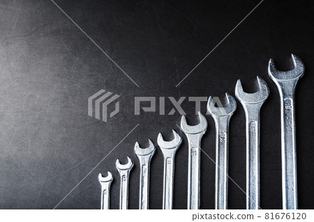 Tool wrenches in a row on a black background with free space. 81676120