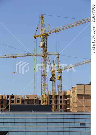 Tower crane and reinforced building under construction project site against blue sky. Tower crane and reinforced building under construction project site against blue sky. 81677306