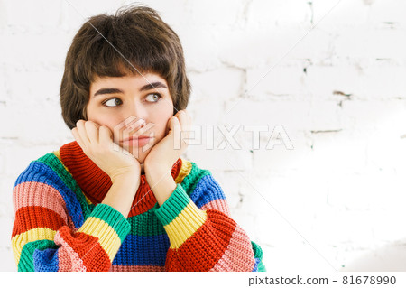 Close-up portrait of attractive sad bored wavy girl in rainbow sweater missing 81678990