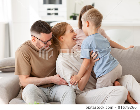 Happy beautiful family having fun and playing while relaxing on sofa in living room Happy beautiful family having fun and playing while relaxing on sofa in living room 81679266