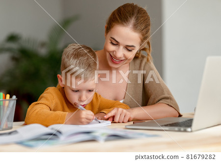 Happy mother supporting son during online studies 81679282